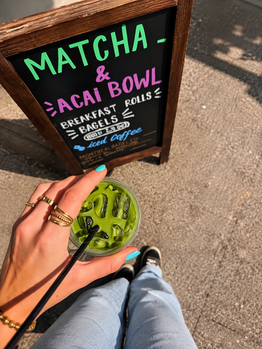 Iced matcha drink beside the café matcha sign at Blend Coffee Shop